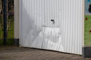 https://depositphotos.com/photo/white-damaged-garage-door-shows-accident-car-crash-drunk-driver-462200432.html